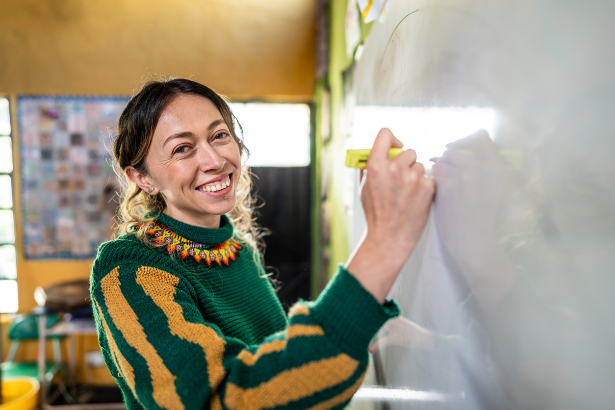 Educator smiles at whiteboard